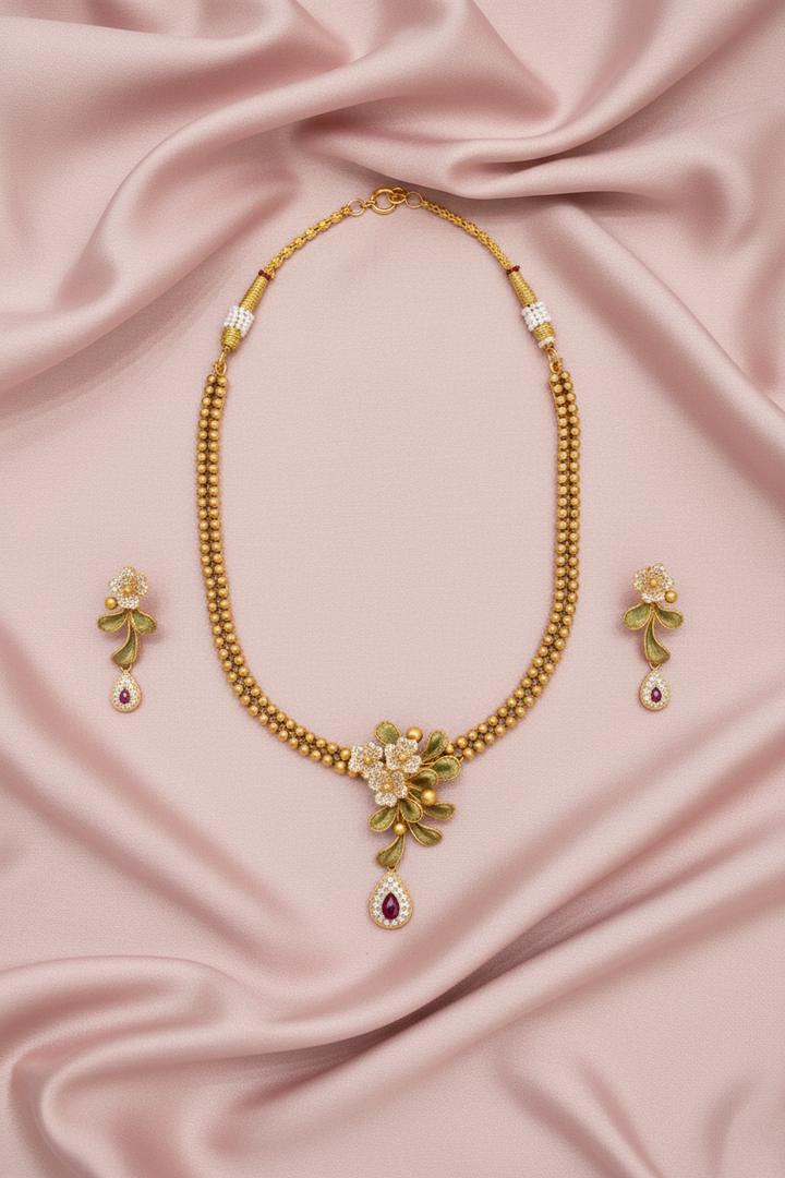 Gold Floral Necklace Set Flat Lay on Pink Satin