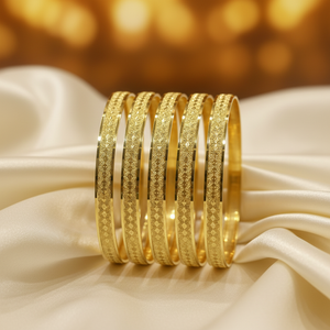 22Kt Diamond-Cut Starburst Gold Bangles on satin fabric